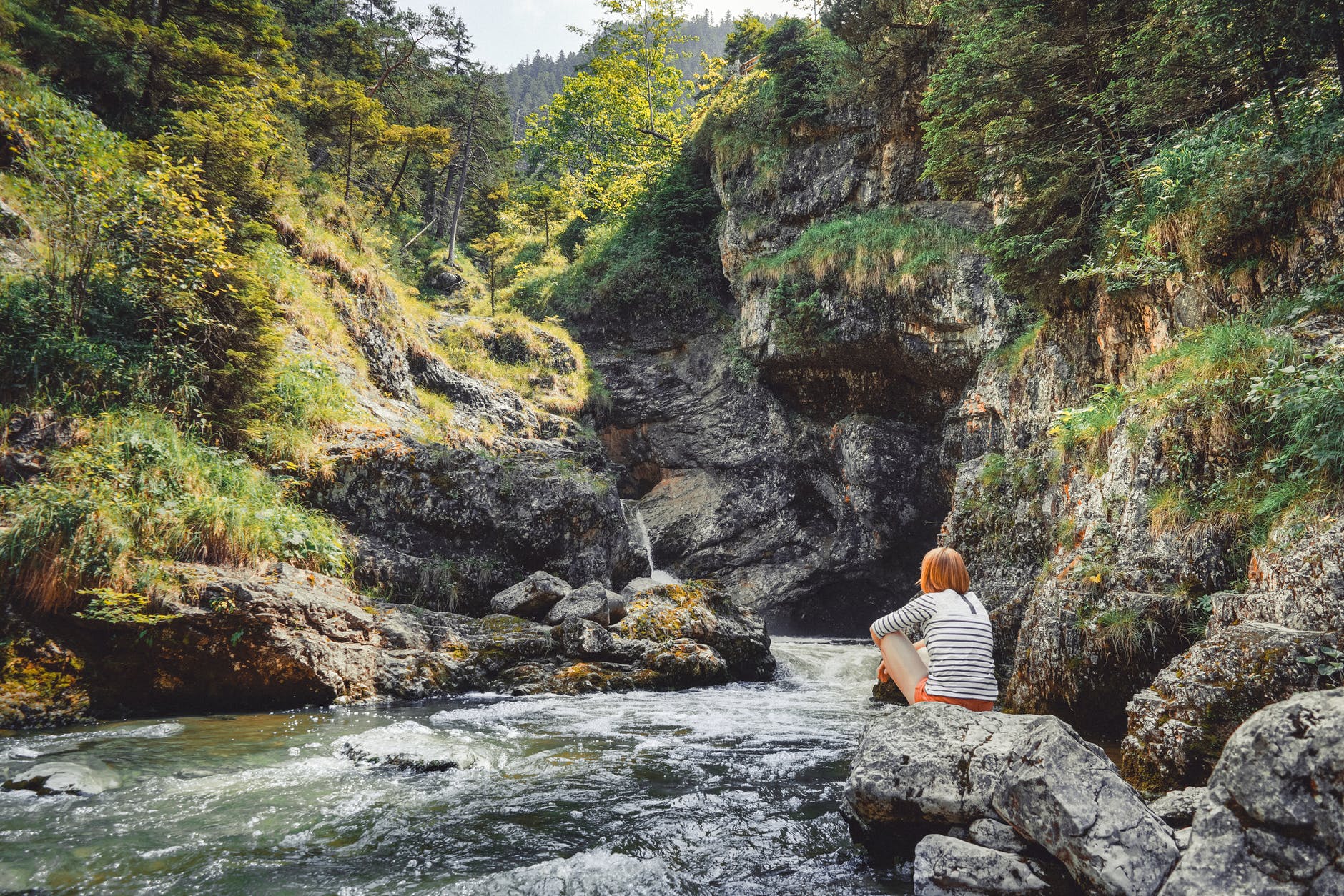 woman on rock near to body of water